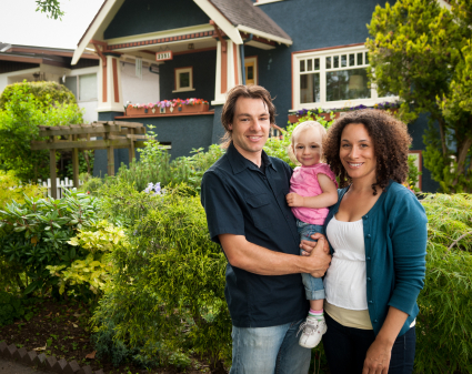 Small family in front of house